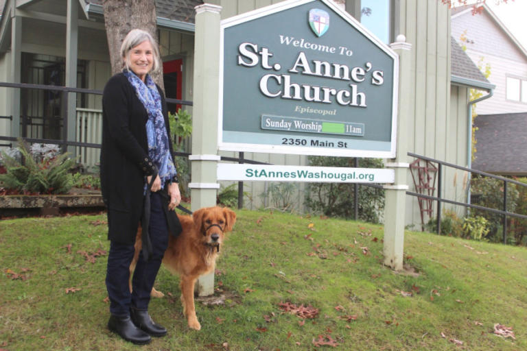 Rev. Annie Calhoun and her dog, Buddy, stand outside St. Anne's Church in Washougal, Nov. 8, 2022.