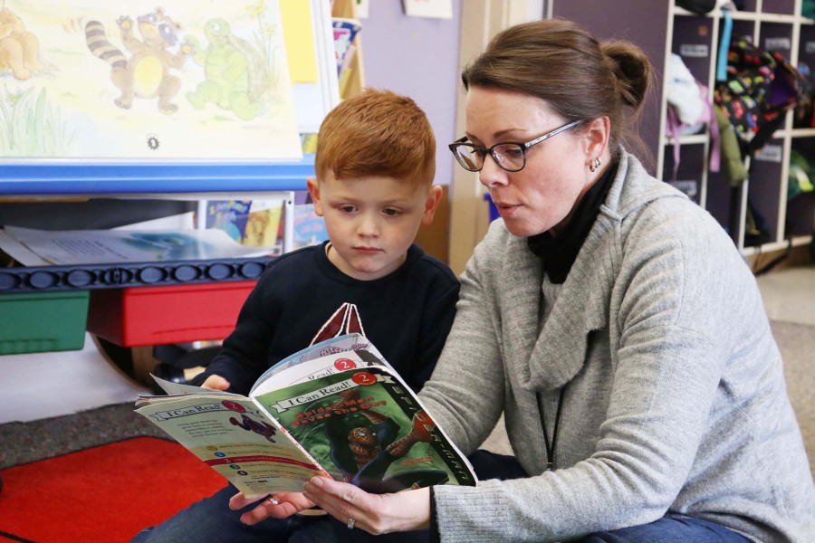 A 4-year-old student reads a book with a staff member during a Washougal School District Transition to Kindergarten class in 2024. (Contributed photo courtesy ashougal School District)
