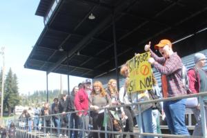 Washougal High School students (right) hold up a sign while walking out of Fishback Stadium, April 10, 2024, at the conclusion of a student walkout to protest Washougal School District’s proposed budget cuts. (Doug Flanagan/Post-Record)