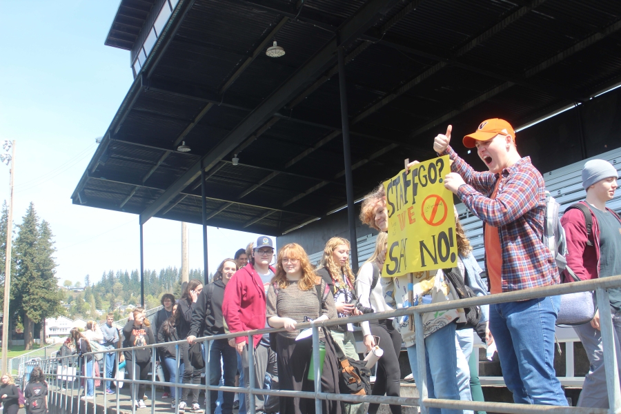 Washougal High School students (right) hold up a sign while walking out of Fishback Stadium, April 10, 2024, at the conclusion of a student walkout to protest Washougal School District&rsquo;s proposed budget cuts. (Doug Flanagan/Post-Record)