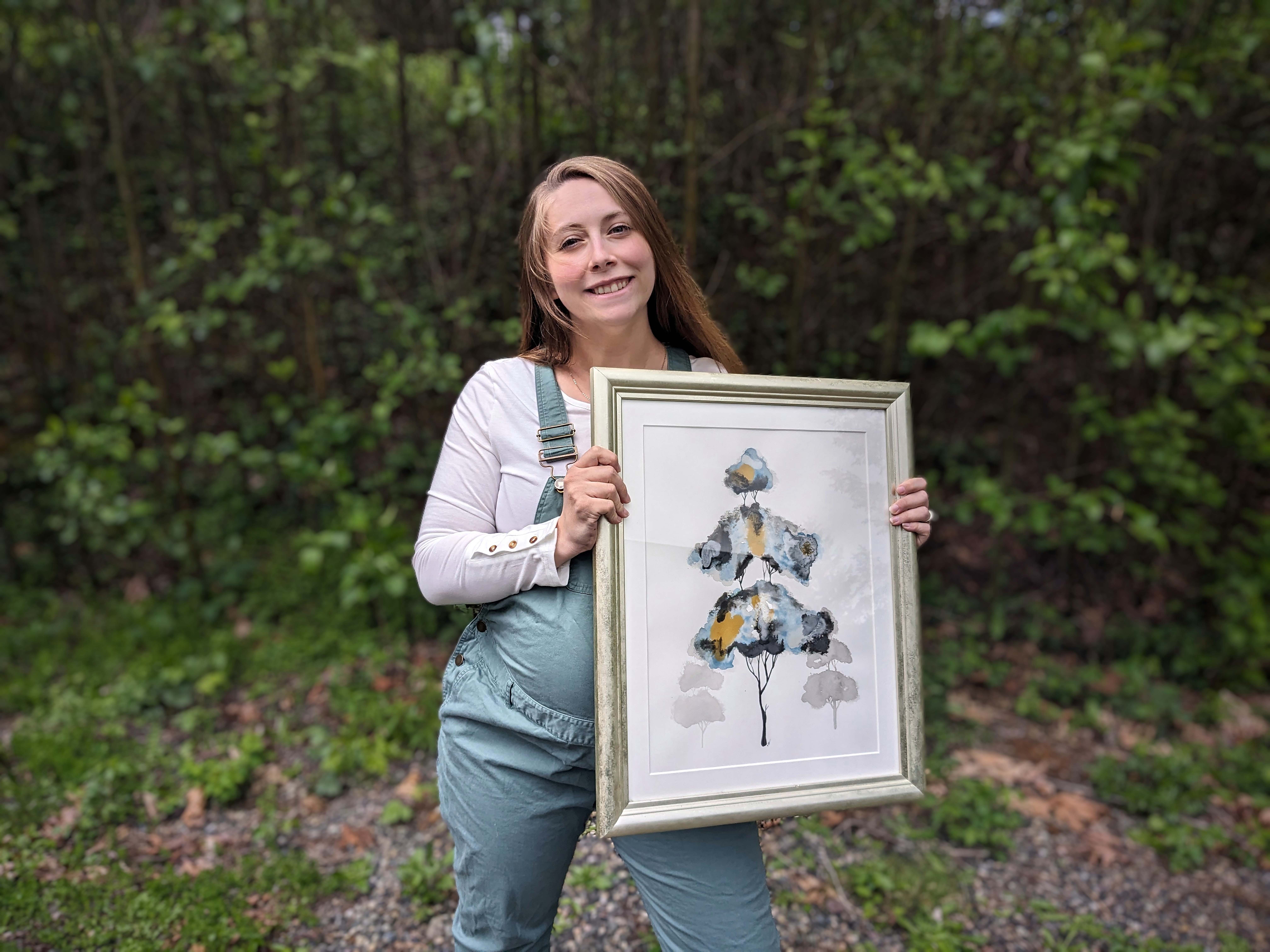 Washougal resident Makayla Blum holds one of her art pieces in April 2024. Blum is one of 23 local studio artists participating in the 2024 Washougal Studio Artists’ 2024 Spring Studio Tour. (Photo courtesy of Makayla Blum)