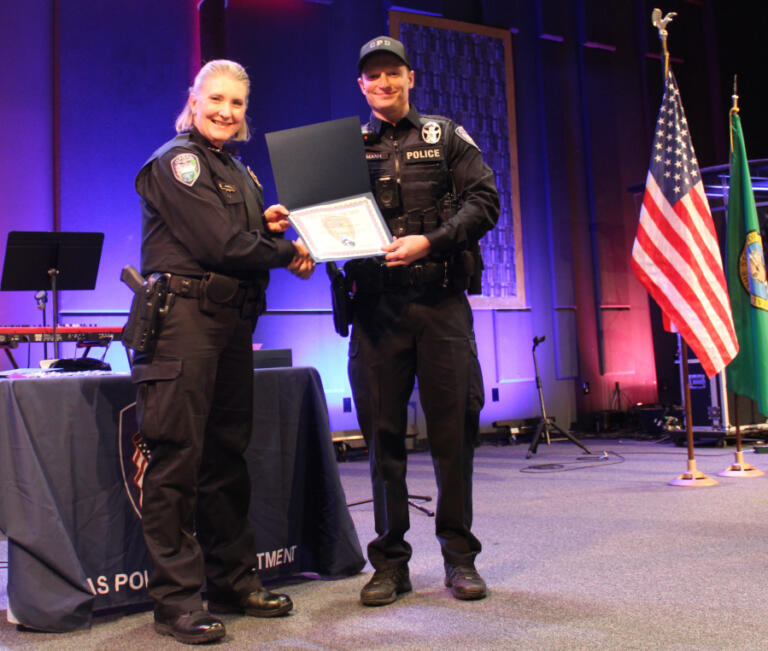 Camas Police Chief Tina Jones (left) presents a Lifesaving Award to Camas police officer Kevin Hermann at Grace Foursquare Church in Camas, Thursday, May 23, 2024.