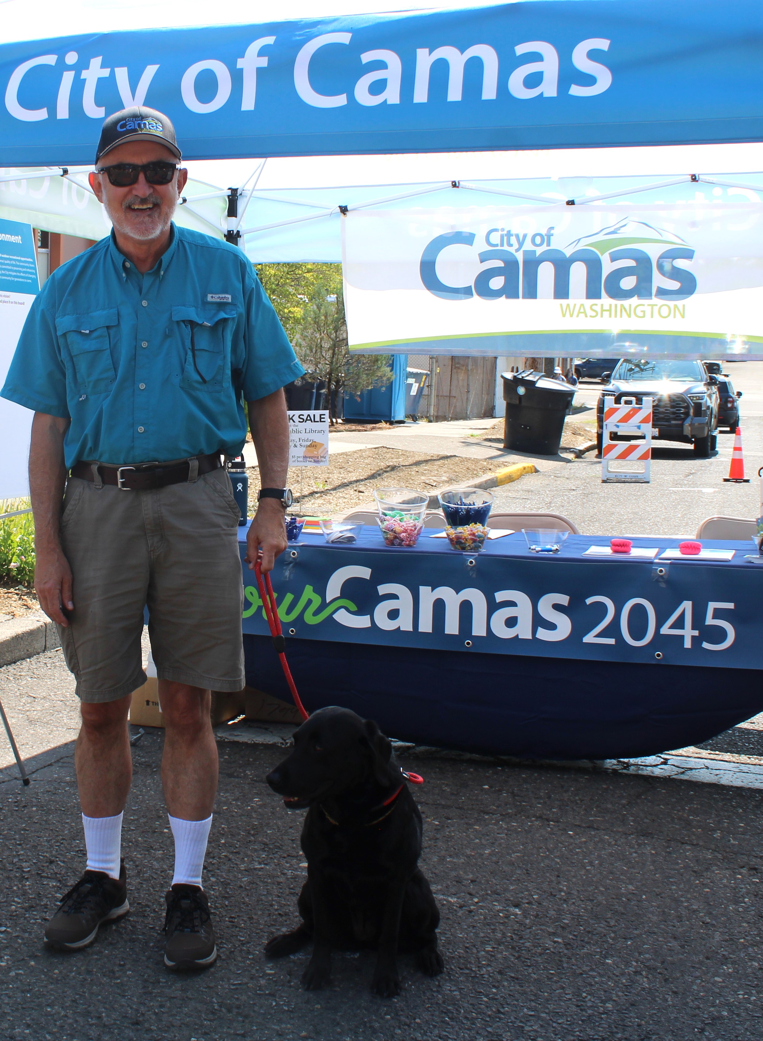 Camas City Councilman John Svilarich and his 8-year-old dog, Frankie, greet visitors to the City's booth during the first day of the 2024 Camas Days festival on Friday, July 26, 2024. (Kelly Moyer/Post-Record files)