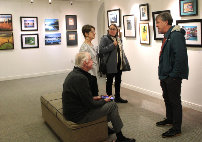 Leslie Struxness (second from left) and her husband, Les (left), greet old friends, Katherine Vaughn (second from right), a retired Vancouver pediatrician, and her husband, Roger, at the reception for Struxness&rsquo; photography show in Camas on Friday, Jan. 3, 2025.