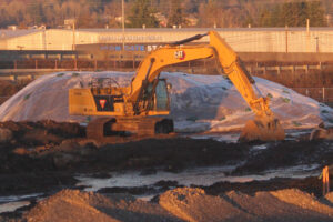 An excavator sits at the Hyas Point waterfront development construction site on Wednesday, Jan. 15, 2025. (Doug Flanagan/Post-Record)