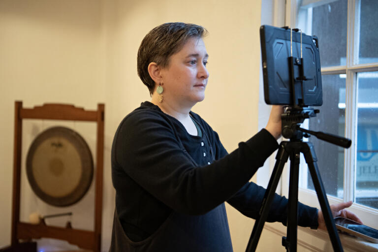 Jacquie Hill, the director and founder of LiveWell Camas, gets a Zoom call dialed in before leading a fitness class in person and virtually in downtown Camas on Friday morning, Jan. 10, 2025.