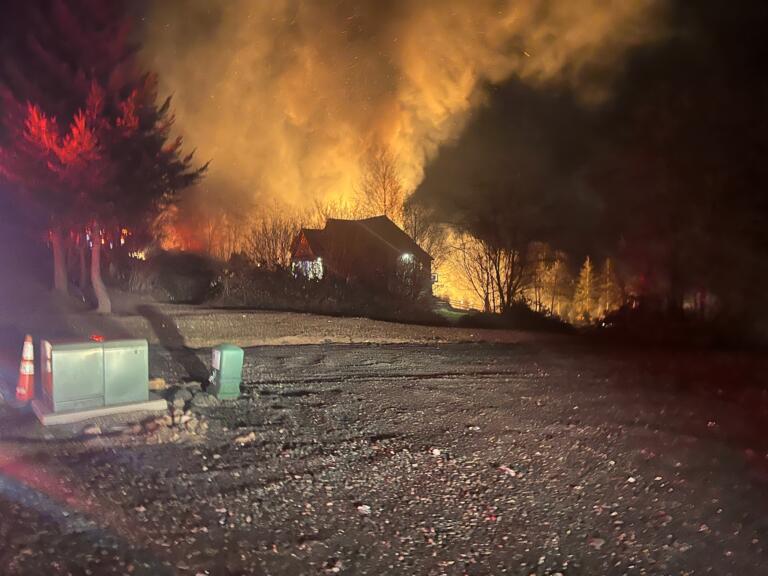 A home is threatened by a structure fire at a nearby residence on Northeast Livingston Mountain Circle in Camas early Sunday morning, Jan. 26, 2025.