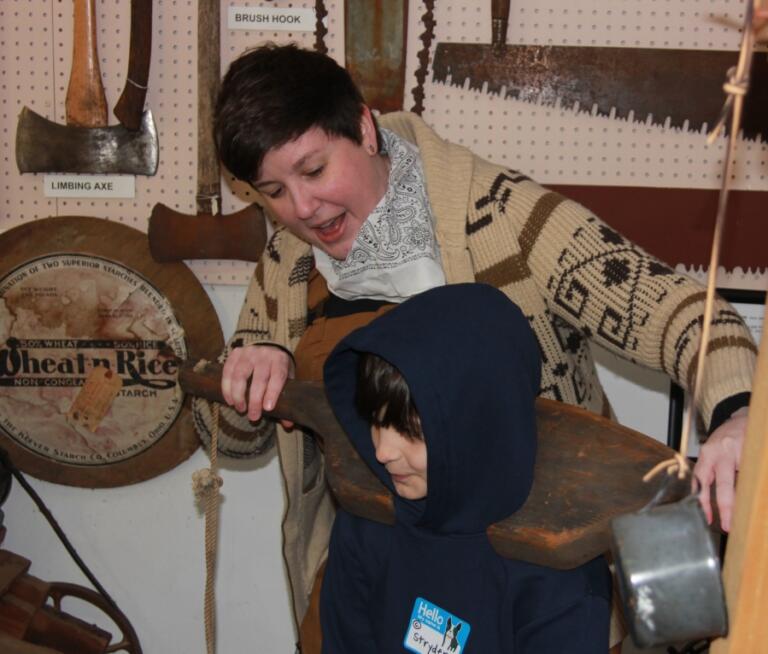 Contributed photo courtesy of Washougal School District 
 A volunteer and a Gause Elementary School student demonstrate yoke used to carry water during a field trip at Two Rivers Heritage Museum on Jan. 28, 2025.