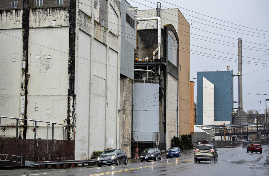 Motorists pass by the Sixth Avenue side of the Georgia-Pacific mill in Camas on Monday morning. Founded in 1883, the Camas paper mill has been owned and operated by Georgia-Pacific, a subsidiary of Koch Industries, since 2000. (Amanda Cowan/The Columbian)