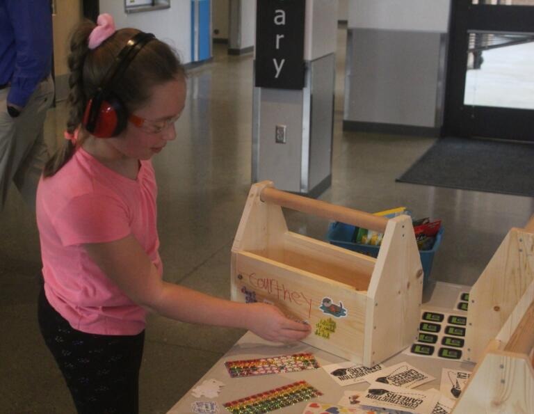 Columbia River Gorge Elementary School student Courtney Baker puts a sticker on her toolbox at the school Feb. 25.