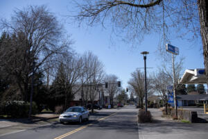 A motorist passes an empty lot, left, along Main Street in Washougal. Vancouver Housing Authority is looking to purchase a parcel of land at 1500 Main St. in Washougal to build more senior housing. (Amanda Cowan/The Columbian)