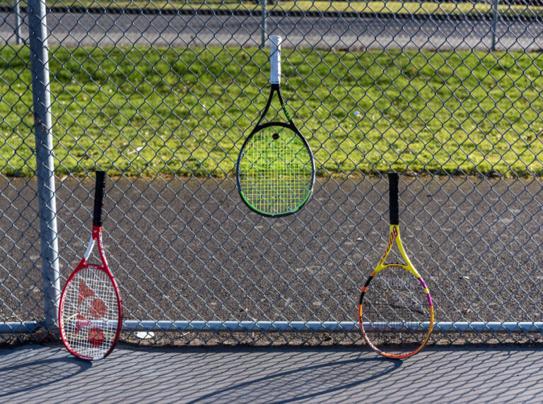 Tennis rackets lean against a chainlink fence Friday at Camas High School. The owners of a private tennis facility in Camas have voiced concerns over a Camas School District plan to build an all-weather dome over the outdoor courts and give the U.S. Tennis Association a 30-year contract to run the tennis facility and open it to paying members of the public.