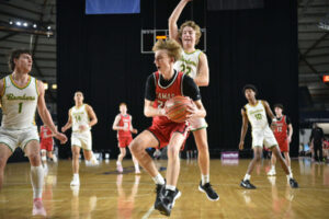 Camas’ Channing Nesland drives the lane against Richland’s Jackson Woodard (22) and Landen Northrop (1) on Saturday. (Meg Wochnick/The Columbian)
