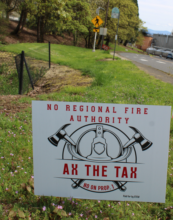 Drivers pass an &ldquo;Ax the Tax&rdquo; sign Thursday on Northwest Sixth Avenue, near the Georgia-Pacific paper mill in Camas. (Kelly Moyer/The Columbian)