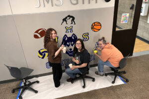 Jemtegaard Middle School students Rylee Drake, left, and Aubrey Gale, center, and art educator Dani Allen paint a mural at the school in March 2024. (Courtesy of the Washougal School District)
