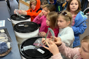 Gause Elementary School students place coins and bills in buckets in the school library in March 2025. (Courtesy of Nicole Mitchell)