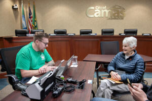Clark County staffer Paul Herkert, left, works with Jackie Faley of Washougal as she helps her grandson, not pictured, sign up for the county’s property tax relief program at Camas City Hall on Friday afternoon. (Photos by Amanda Cowan/The Columbian)