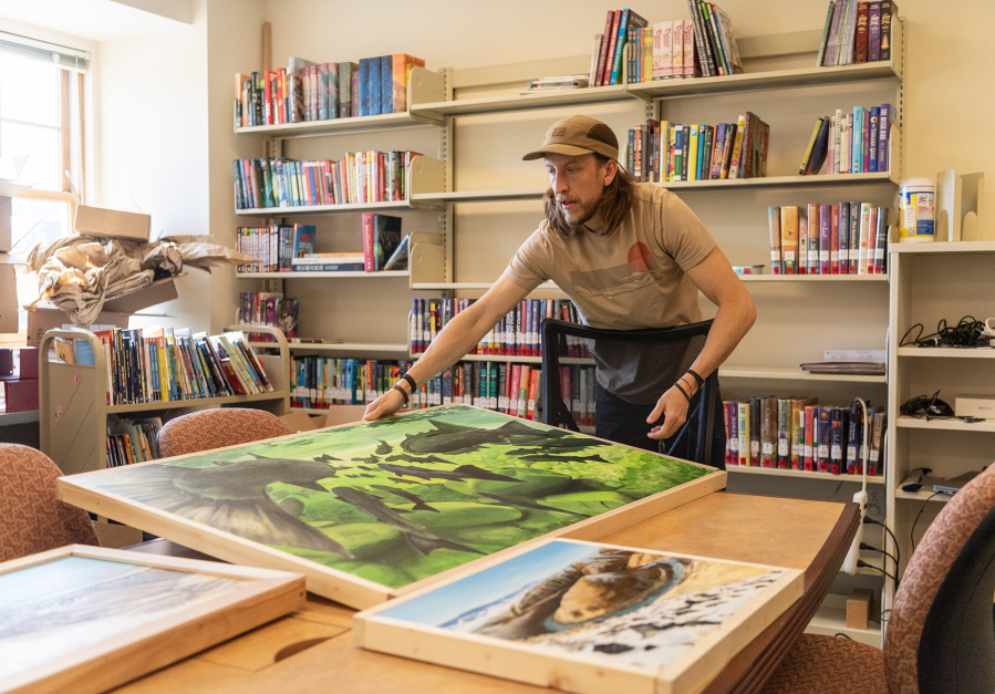 Artist Travis London sets an art piece on a table Friday, April 25, 2025, at the Camas Public Library. The Second Story Gallery, on the second floor of the Camas library, has selected London for its new artist-in-residence program. (Photos by Taylor Balkom/The Columbian)